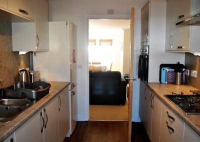 View of kitchen towards door. Sink to the left, hob and oven to right