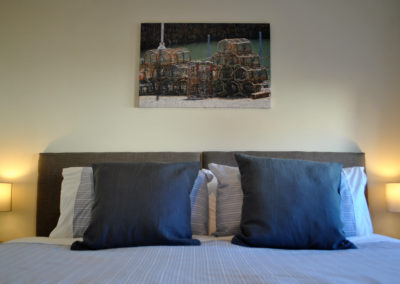 Super king size bed with photograph of fishing creels on wall