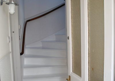 Wooden stairs painted white, as seen through a doorway