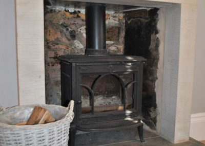 Wood burning stove with basket of logs