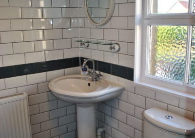 Fully tiled bathroom with sink and toilet