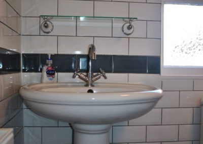 Sink with mixer tap and circular mirror above