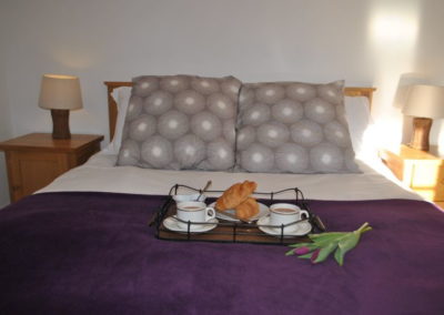 Double bed with wooden bedside tables and lamps