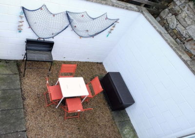 The sunny courtyard has seating and a barbecue