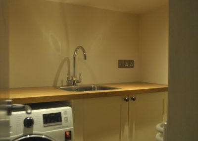 Utility room shows a washing machine and sink
