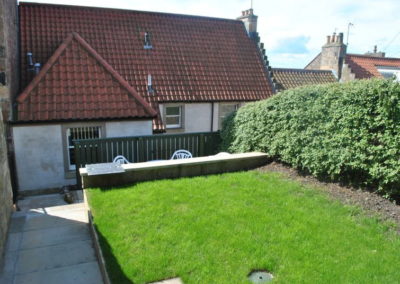 The garden to the rear offers a grassed area and seating