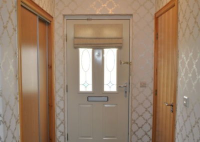 Wide hallway with cupboard to left and WC to right