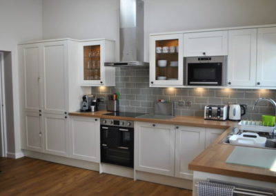 Modern, cream-fronted kitchen cabinets and electric oven