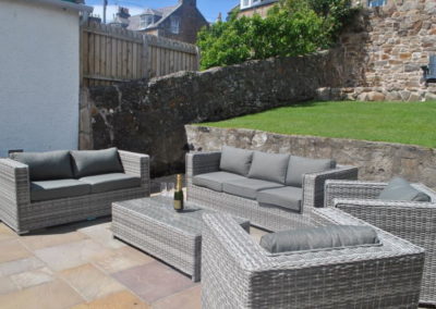 Patio area with outdoor wicker-backed sofas and chairs