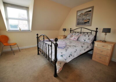 Metal framed double bed in room with sloping ceiling