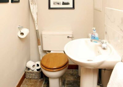 Tiled floor in the WC. An oar sits behind the toilet!
