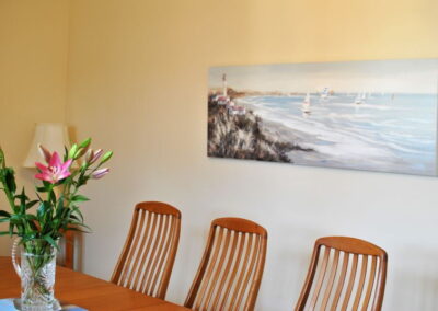 Seaside scene on image on the wall above the table.