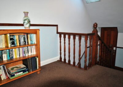 Bookcase on the landing, a short distance from the top of the stairs
