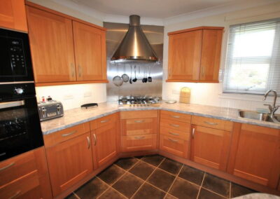 Wooden kitchen units and tiled floor.