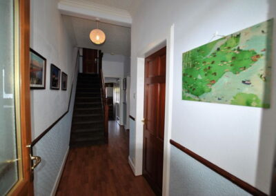 Corridor with image on wall on right and stairs at the end of the passageway