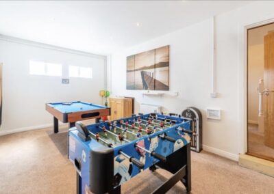 Carpetted room with pool table and table football