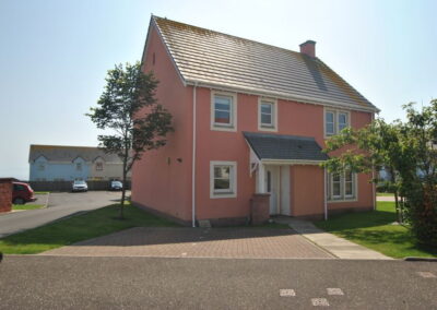 Peach coloured house with front door covered by a small roof