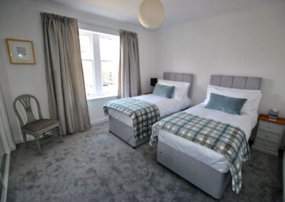 Two single beds side by side with window on left