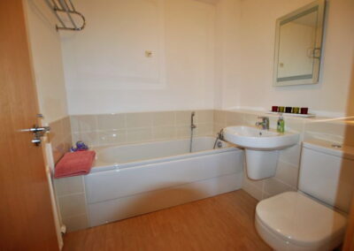Bath, sink, toilet. Towel rail on wall above bath.