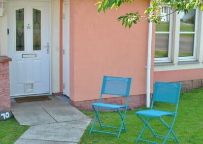 Folding chairs on grass outside front door