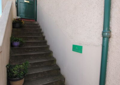 Outside staircase leads to green front door