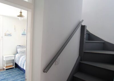Angular curved staircase hugs bedroom on the left