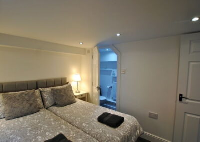 Twin beds pushed together. En-suite WC in far corner.