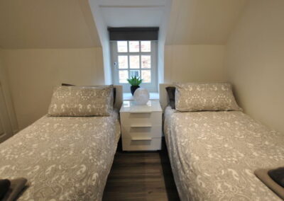 Single beds separated by a three-drawer bedside table