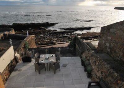 Beach and rocks can be seen below the patio