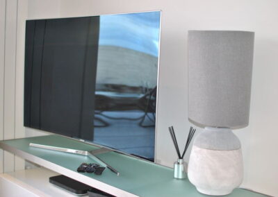 Reflection of patio on the TV screen. Lamp next to TV.
