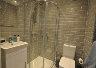 Grey, tiled walls with white fittings