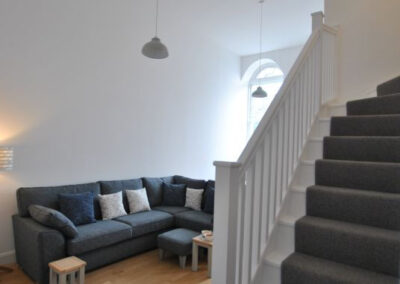 Corner sofa on left, stairs up to right