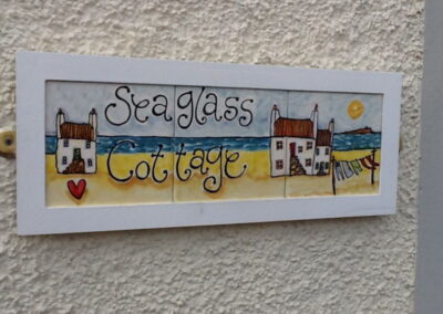 Tiled sign reads Seaglass Cottage