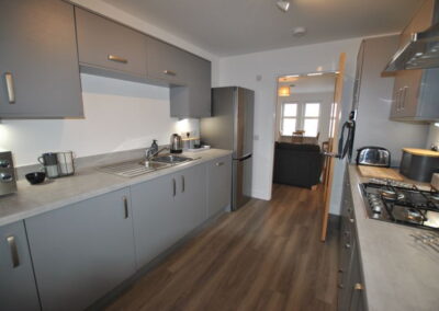Plenty of cupboards, a large fridge freezer and a door through to the open plan lounge and dining area.