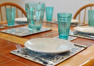 White plates, green glasses and cutlery on table
