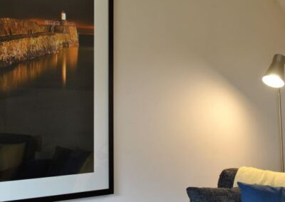 Large, framed picture on wall next to armchair
