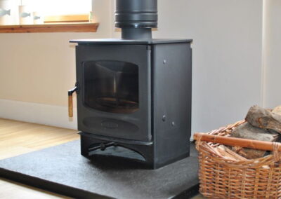 Wood burning stove with basket of logs