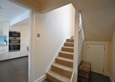 Door to kitchen, hallway with stairs up