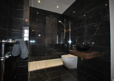 The en suite shower room is modern and fresh