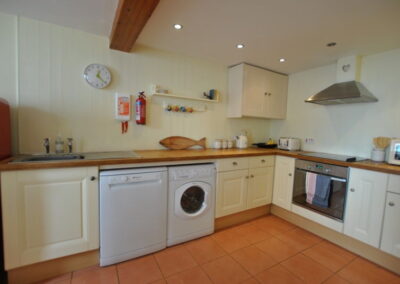 Wooden walls and kitchen units. Fully fitted kitchen with dishwasher and washing machine