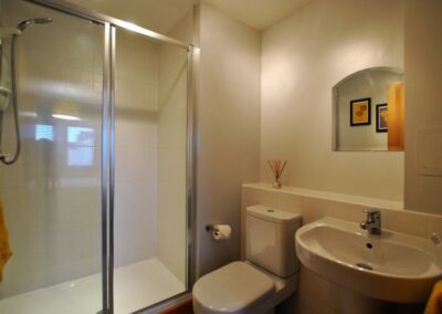 White bathroom suite with wide walk-in shower
