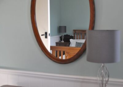 Reflection of bed in oval mirror