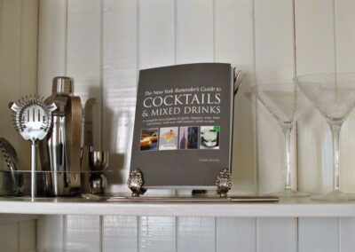 Shelf with cocktail making equipment and book