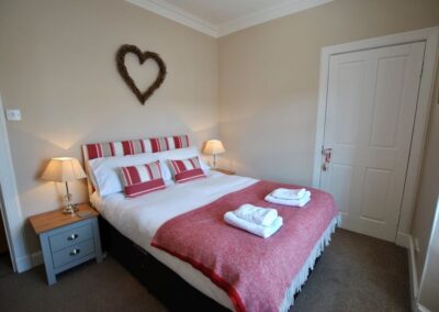 Double bed with a heart artwork on the wall above the bed