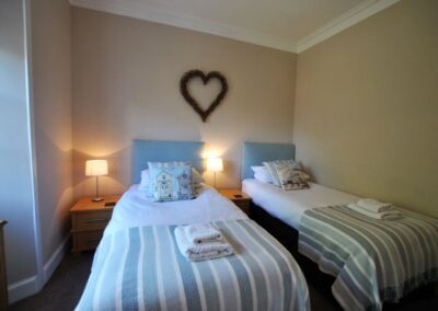 Two single beds with bedside tables on the left of each