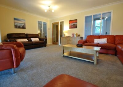 View across lounge, coffee table and sideboard, towards door