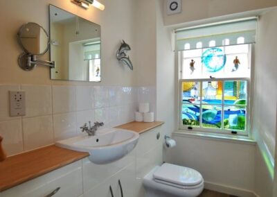 Stained glass window at end of bathroom