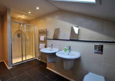 Tiled bathroom with double sinks and large walk-in shower