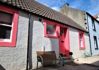 Tiled roof and bright, deep pink surrounds to doors and windows