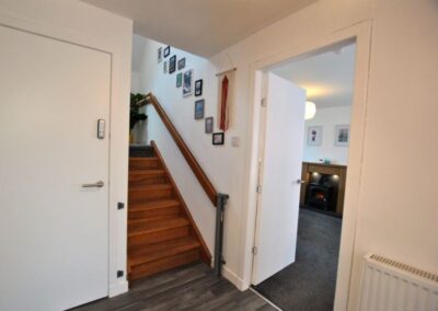 To the right of a short staircase is an open door to the living room